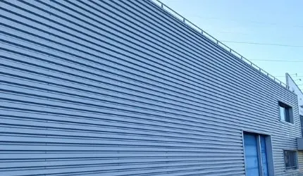 Après : bardage métallique nettoyé, teinte bleu-gris homogène