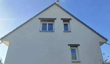 Pignon de maison à l’enduit clair après nettoyage de façade